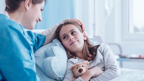 Nurse taking care of girl in hospital