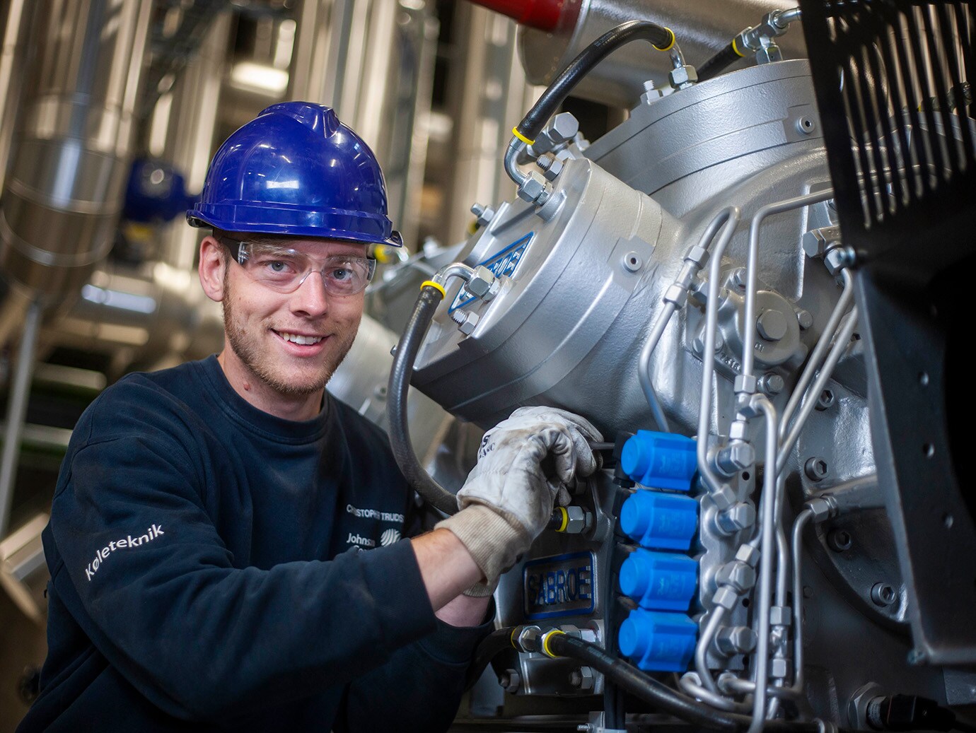 A worker in blue uniform fixing the engine in the factory
