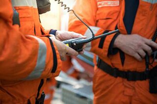 Close up of a worker holding a walkie talkie