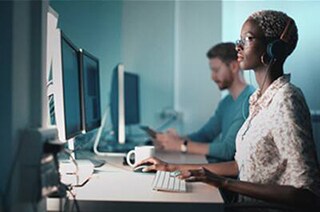 Close-up of the employees working in a cubicle on computer