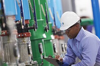 A supervisor taking the readings on the floor of a manufacturing unit