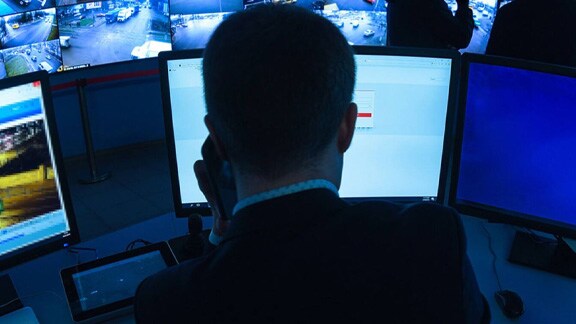 Close up of a security personnel watching the CCTV footages in the control room