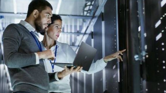 A man and a woman having a discussion in a data center